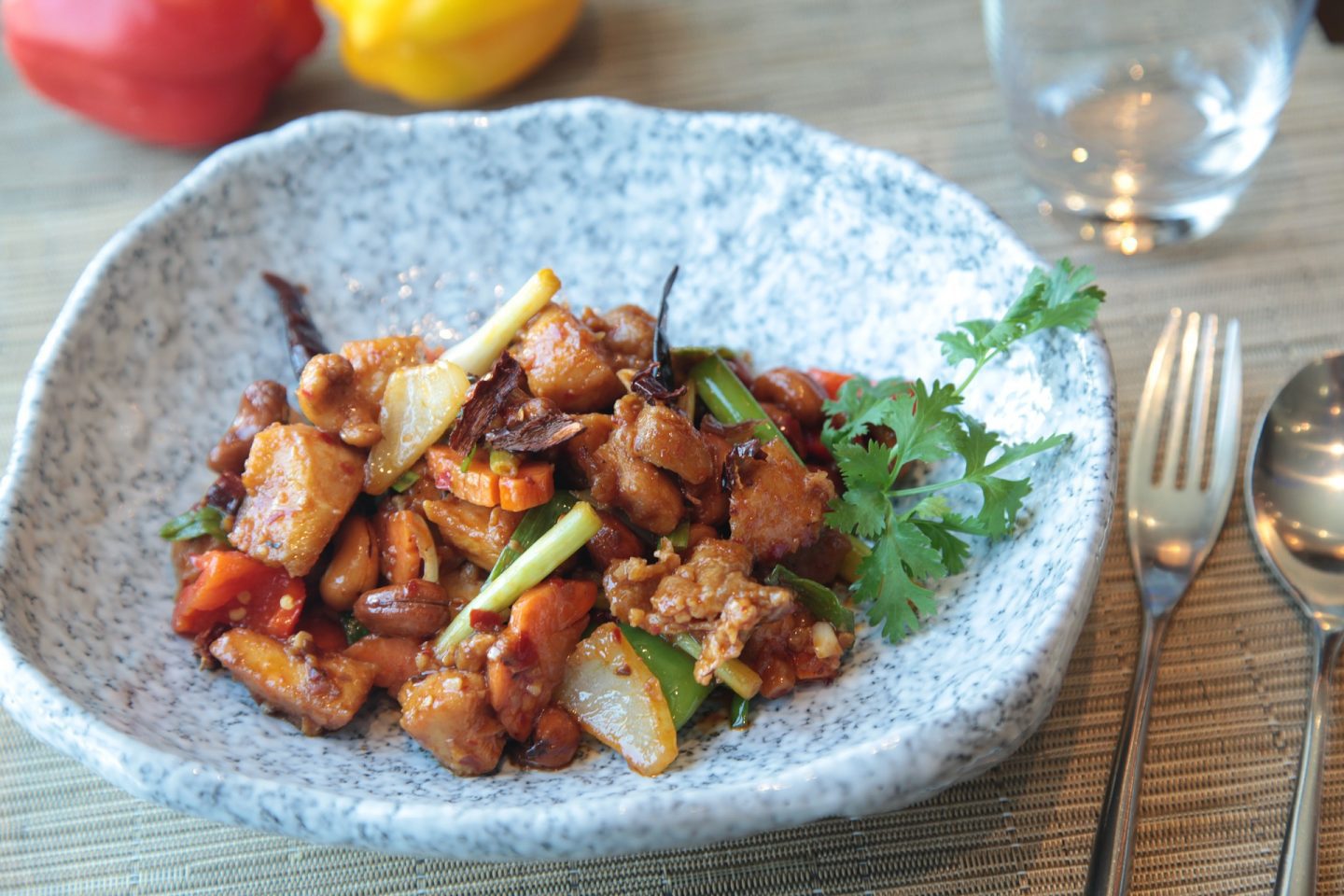 A large dish containing sweet and sour chicken and garnish, a potential freezer meal