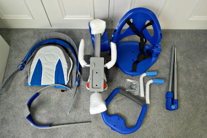 The blue parts of an unassembled push along trike