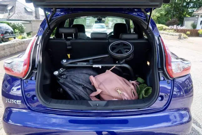 The boot of a Nissan Juke with a large pram and a changing bag in the boot