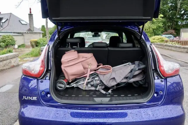 The back of a Nissan Juke with the boot open and a stroller and changing bag placed inside