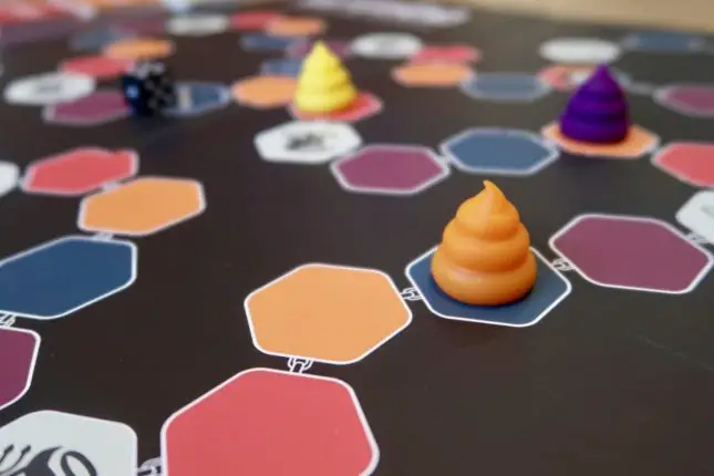 A board game with poo shaped brightly coloured playing pieces and hexagonal spaces