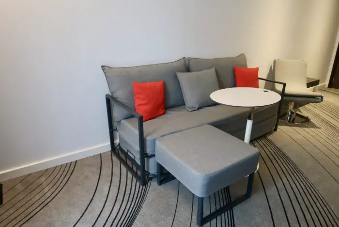 A small sofa, table and footstool in a hotel room