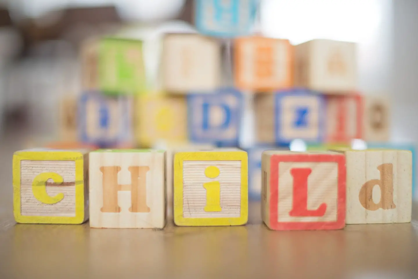 Wooden children's building blocks spelling out "child"