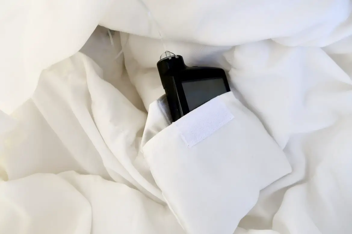 An insulin pump sits within a hidden pocket on the inside of a wedding dress