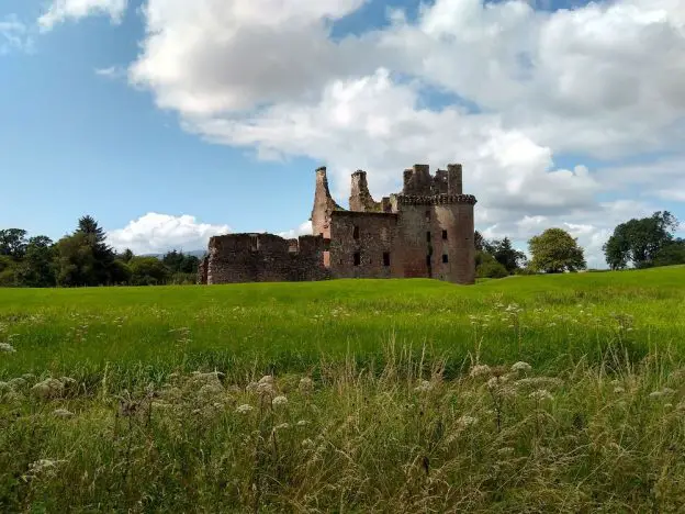Caerlaverock Castle in Dumfries set at the back of the photo with a large lawn in the foreground