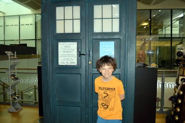 A child standing in front of the Tardis from Dr Who in the BBC Visitor Centre in Brimingham