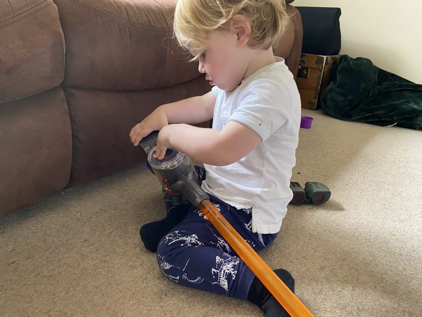 A toddler playing with a vacuum cleaner toy