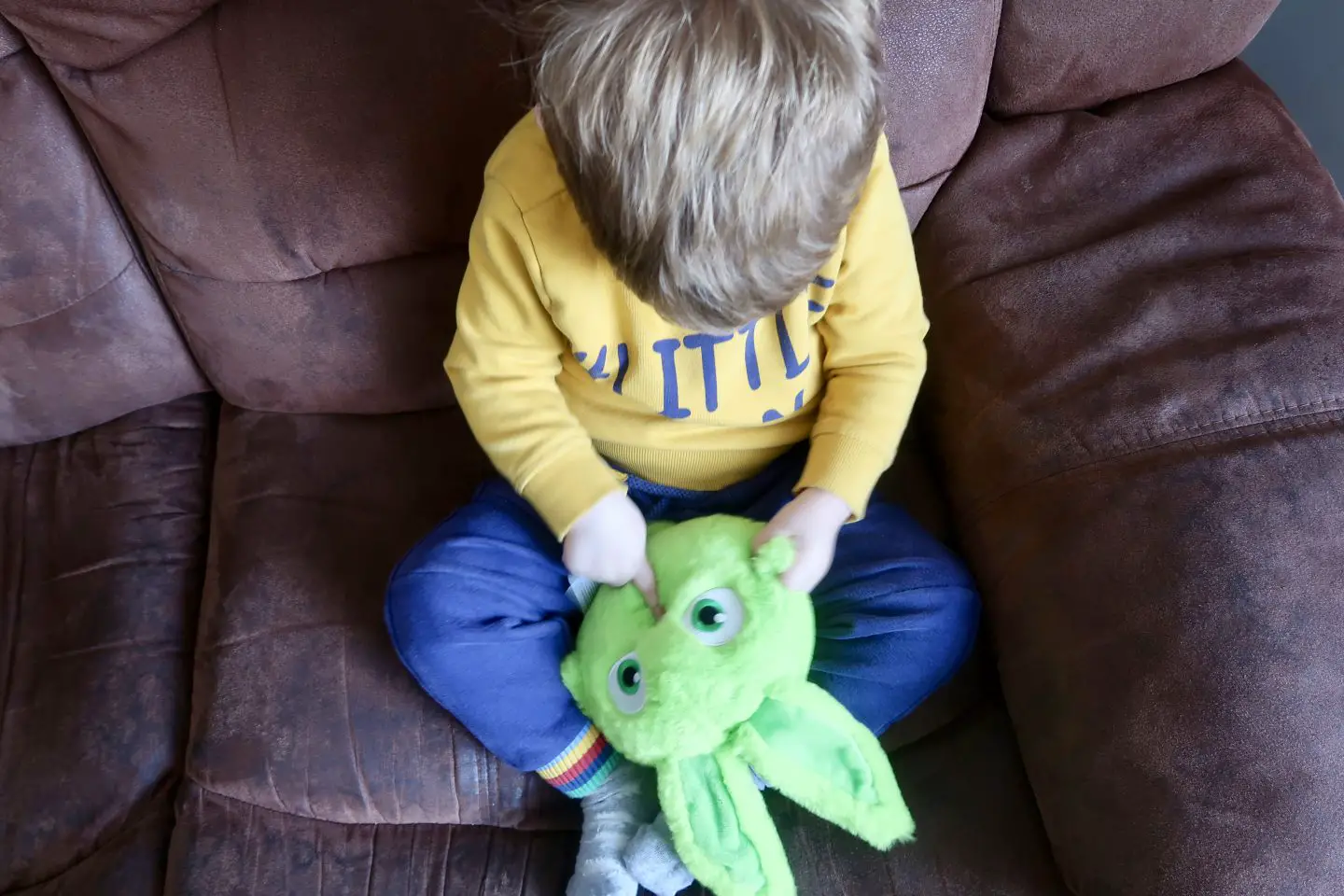 A little boy touching the mouth of a Sunny Bunnies toy