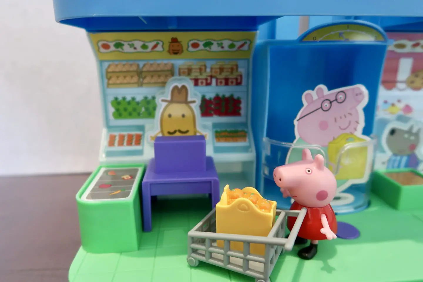 A Peppa Pig figure with a shopping trolley in a toy shop