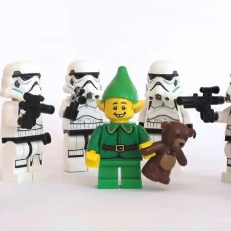 A lego elf surrounded my my lego storm troopers