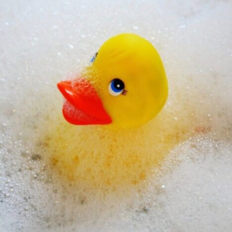 A yellow rubber duck in a bubble bath.