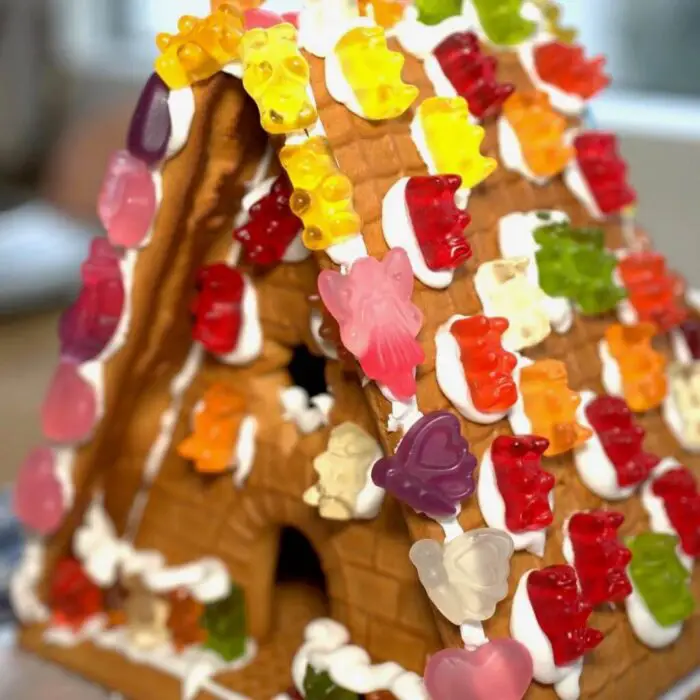 A gingerbread house covered in gummy bears