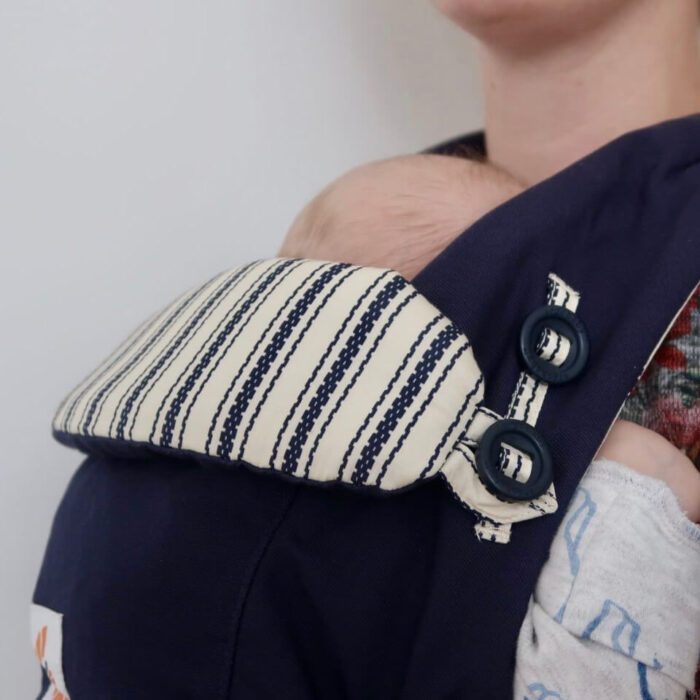 A navy blue baby carrier with a baby in it
