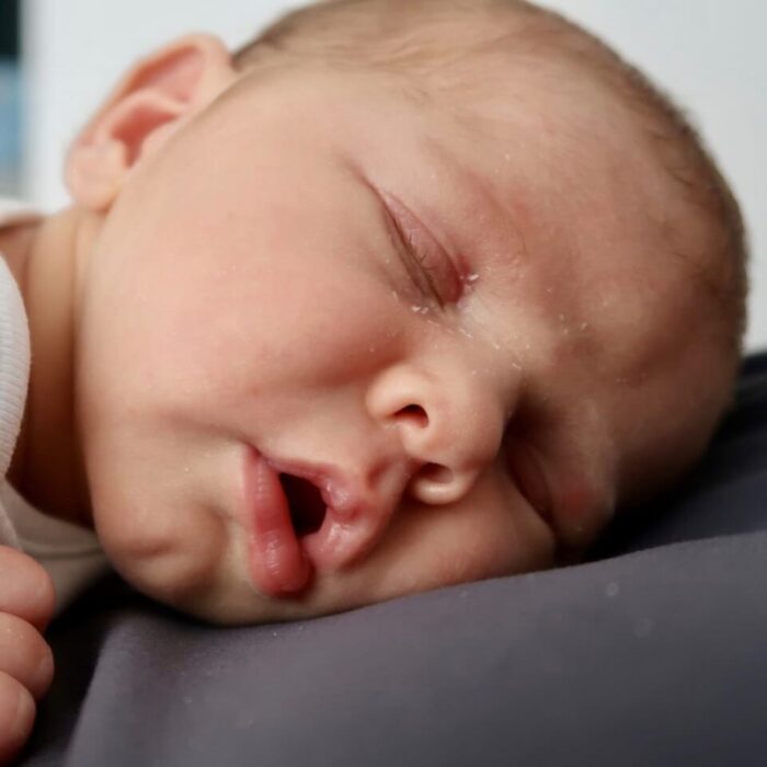A newborn asleep on its stomach