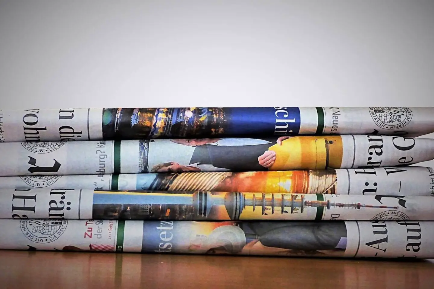 A stack of newspapers on a wooden table