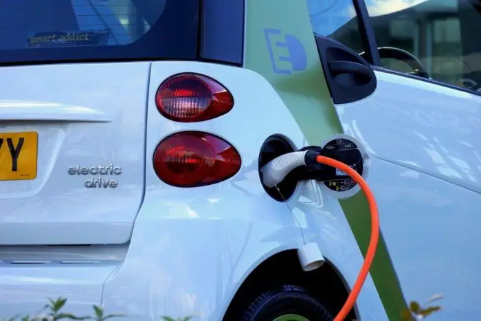 A small electric car plugged in to charge