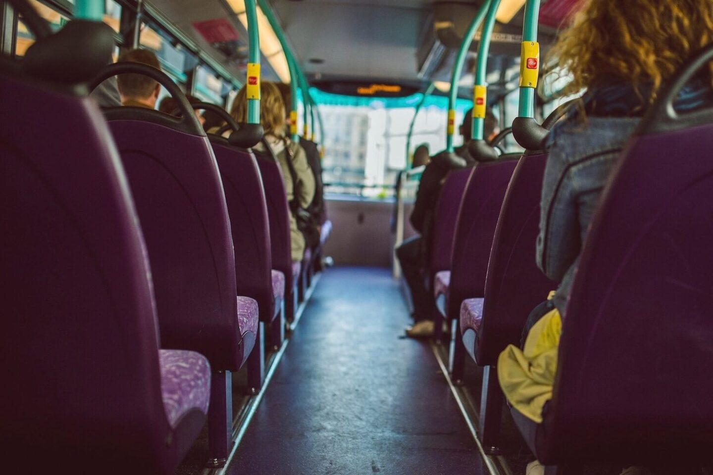 Looking down the centre of a bus with seats on either side