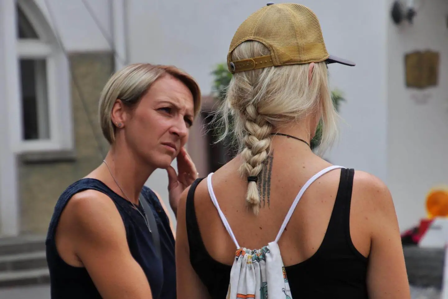 2 blonde women talking. The face of one is showing concern
