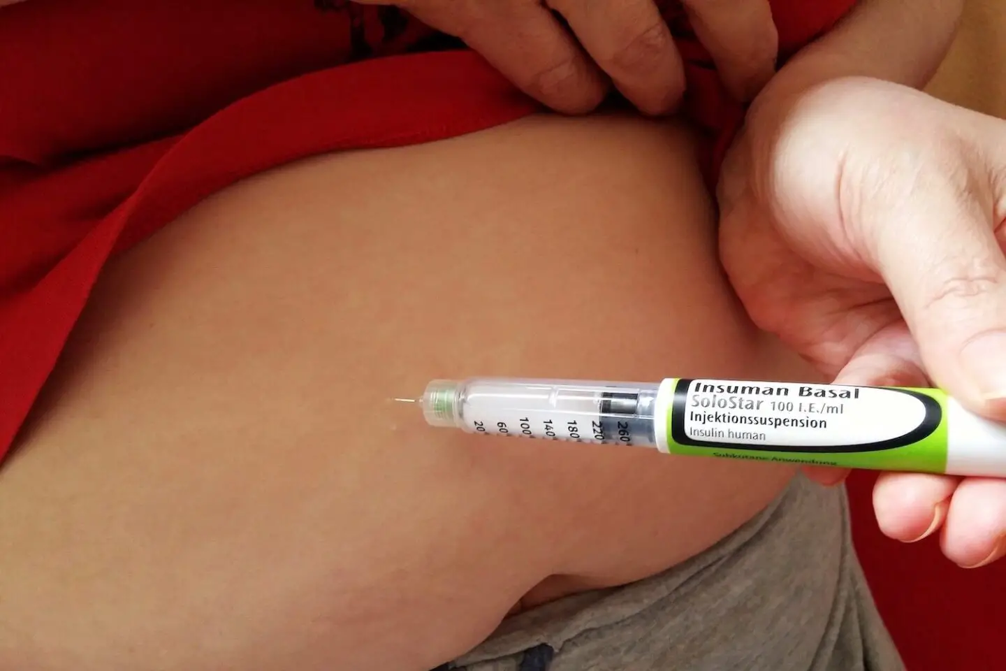A person injecting basal insulin into their stomach