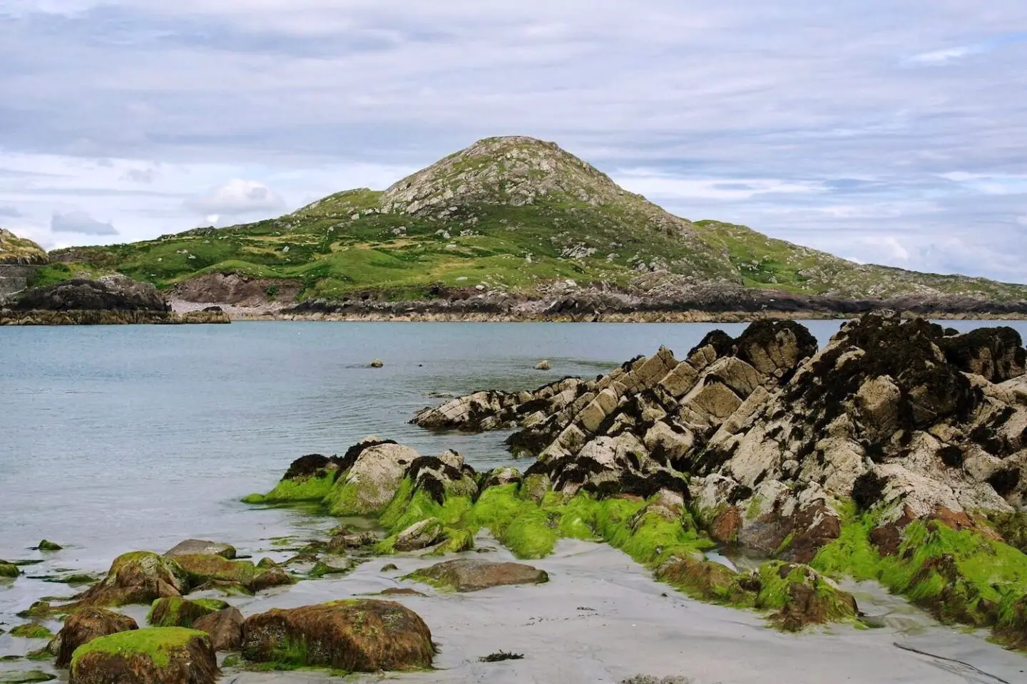 The coastline in Ireland. A hill and rocks surrounded by water